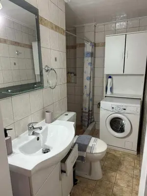 a bathroom with a sink and a washing machine at Zografou Cozy Apartment in the heart of Athens! in Athens