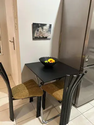 a black table with two chairs and a bowl on it at Zografou Cozy Apartment in the heart of Athens! in Athens
