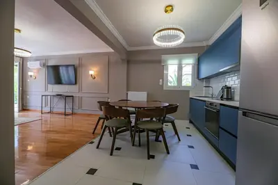 a kitchen with blue cabinets and a table and chairs at Rhapsody in Blue Alimos Marina in Athens