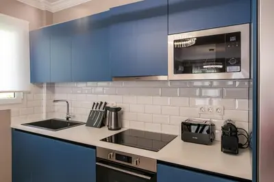 a kitchen with blue cabinets and a counter top at Rhapsody in Blue Alimos Marina in Athens