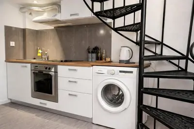 a kitchen with a washing machine next to a shelf at Athens City Staying in Athens