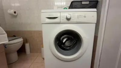 a white washing machine in a bathroom with a toilet at The Stylish Central 2BR Residence for 5 in Athens