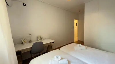 two beds in a room with a desk and a chair at The Stylish Central 2BR Residence for 5 in Athens