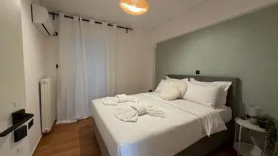 a bedroom with a white bed with towels on it at The Stylish Central 2BR Residence for 5 in Athens