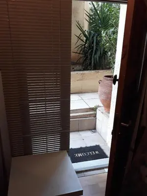 an open door leading to a courtyard with a vase at Studio Poseidonos Avenue in Athens
