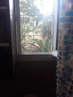 a bathroom window with a view of a plant at Studio Poseidonos Avenue in Athens