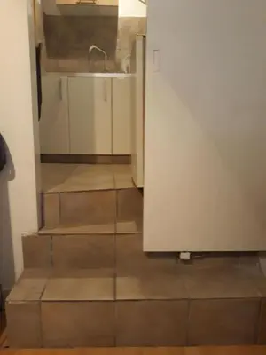 a stairway leading up to a kitchen with a sink at Studio Poseidonos Avenue in Athens