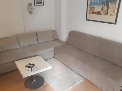 a living room with a couch and a table at Studio Poseidonos Avenue in Athens