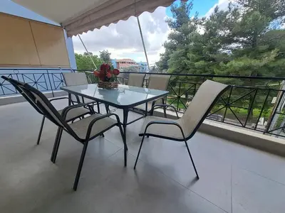 a glass table and chairs on a balcony with a view at Lula Urban Apartment in Athens