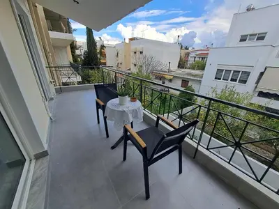 a balcony with a table and chairs on it at Lula Urban Apartment in Athens
