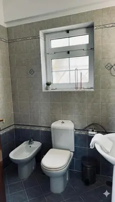 a bathroom with a toilet and a sink and a window at The Lotus House - Premium Coastal Living in Porto Rafti