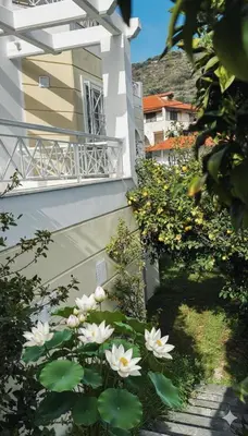 a white building with a balcony and some flowers at The Lotus House - Premium Coastal Living in Porto Rafti