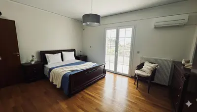 a bedroom with a bed and a chair and a window at The Lotus House - Premium Coastal Living in Porto Rafti