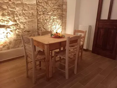 a wooden table with chairs and a bowl of fruit on it at The Fisherman's Romance in Piraeus