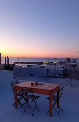 a wooden table and chairs sitting on top of a roof at The Fisherman's Romance in Piraeus