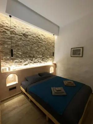 a bedroom with a bed with a fish painting on the wall at The Fisherman's Romance in Piraeus
