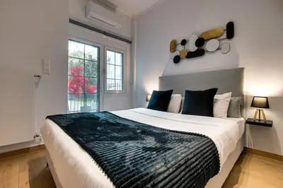 a bedroom with a large bed and a window at Noir & Blanc in the Heart of Nea Smyrni in Athens