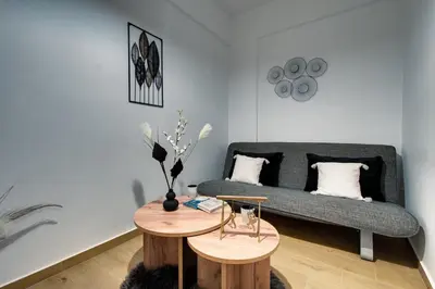 a living room with a couch and two tables at Noir & Blanc in the Heart of Nea Smyrni in Athens
