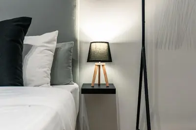 a bedroom with a bed and a lamp on a table at Noir & Blanc in the Heart of Nea Smyrni in Athens