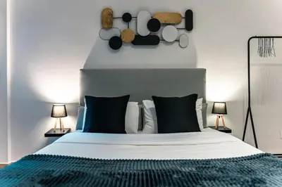 a bedroom with a large bed with black and white pillows at Noir & Blanc in the Heart of Nea Smyrni in Athens