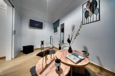 a living room with a wooden table in a room at Noir & Blanc in the Heart of Nea Smyrni in Athens