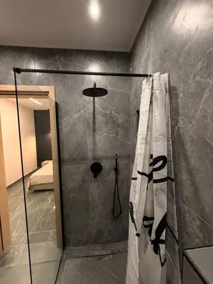 a bathroom with a shower with a glass door at Monda Apartment 3 in Piraeus