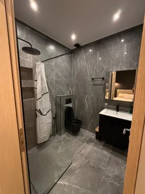 a bathroom with a shower and a sink and a mirror at Monda Apartment 3 in Piraeus