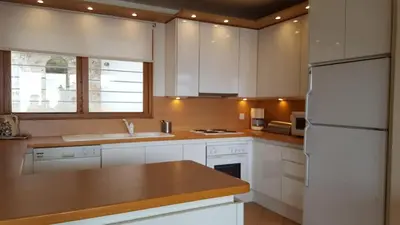 a kitchen with white cabinets and a white refrigerator at Villa Horizon Bleau by A&D Properties in Sounio