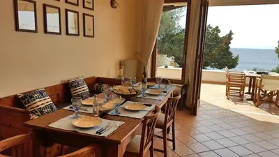 a dining room table with chairs and a large window at Villa Horizon Bleau by A&D Properties in Sounio