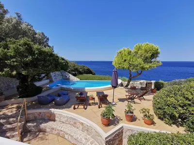 a patio with a pool and chairs and an umbrella at Villa Horizon Bleau by A&D Properties in Sounio