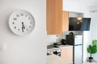 a clock hanging on the wall of a kitchen at Elysian Lycabettus-Resilience in Athens
