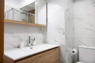 a white bathroom with a sink and a toilet at Elysian Lycabettus-Resilience in Athens