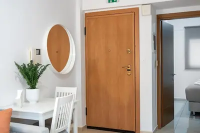 a wooden door in a room with a table and a mirror at Elysian Lycabettus-Resilience in Athens