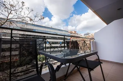 a glass table on a balcony with a view of a building at Elysian Lycabettus-Resilience in Athens
