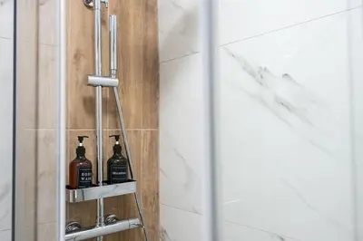 a bathroom with two bottles of alcohol on a shelf at Elysian Lycabettus-Resilience in Athens