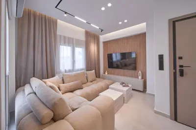 a living room with a large couch and a tv at SOLUNA Hideaway Athens - Luxury Jacuzzi Suite in Athens