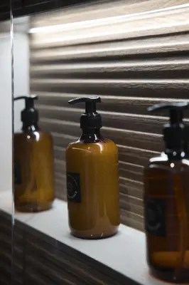 a row of three soap dispensers sitting on a shelf at SOLUNA Hideaway Athens - Luxury Jacuzzi Suite in Athens