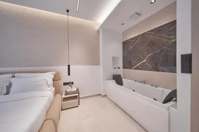 a bedroom with a bed and a bath tub at SOLUNA Hideaway Athens - Luxury Jacuzzi Suite in Athens