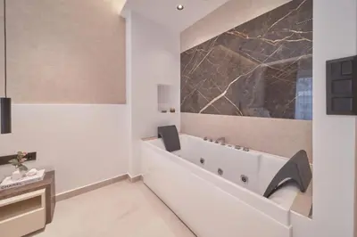 a bathroom with a tub and a sink at SOLUNA Hideaway Athens - Luxury Jacuzzi Suite in Athens