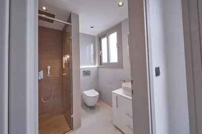 a bathroom with a shower and a toilet and a sink at SOLUNA Hideaway Athens - Luxury Jacuzzi Suite in Athens