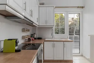 a kitchen with white cabinets and a sink at Eclipse Asklipion Voula in Athens