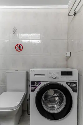 a washing machine in a bathroom next to a toilet at Eclipse Asklipion Voula in Athens