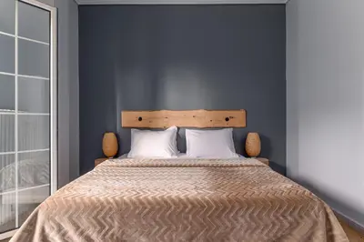 a bedroom with a large bed with a wooden headboard at Eclipse Asklipion Voula in Athens