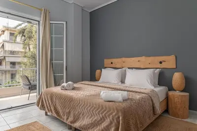 a bedroom with a large bed and a large window at Eclipse Asklipion Voula in Athens