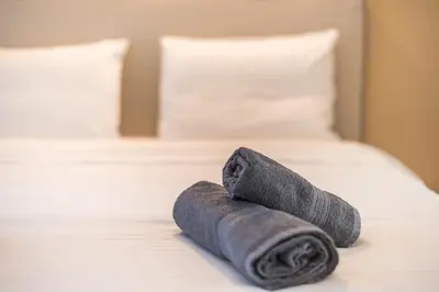 a rolled up gray towel on a bed at Athena House Elegant Stay For Families By Greece Apartments in Athens