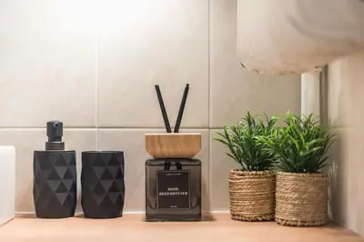 a bottle of perfume on a counter with two plants at Athena House Elegant Stay For Families By Greece Apartments in Athens