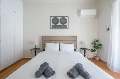 a bedroom with a white bed with two pillows on it at Athena House Elegant Stay For Families By Greece Apartments in Athens
