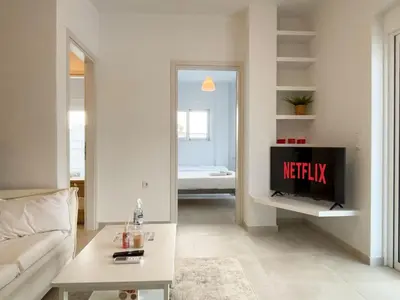 a living room with a tv and a couch at Sunlit Retreat in Voula Center in Athens