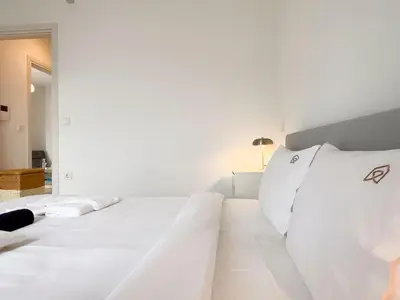 a white bed with white pillows in a room at Sunlit Retreat in Voula Center in Athens