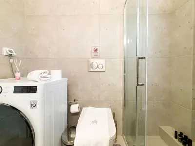 a bathroom with a toilet and a glass shower at Sunlit Retreat in Voula Center in Athens